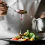 Chef dropping sauce on a plate of food